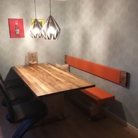 Tisch aus dunklem Holz mit orangener Sitzbank